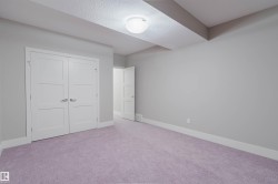 Room featuring violet-hued carpeting, neutral wall paint, and white baseboards - 