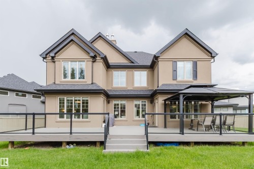 Expansive rear deck featuring glass panel railings, composite decking, and a set of exterior stairs - 3435 Keswick Boulevard, Edmonton, AB 