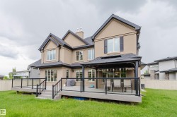 Stucco exterior residence featuring a multi-level deck with glass panel railings - 