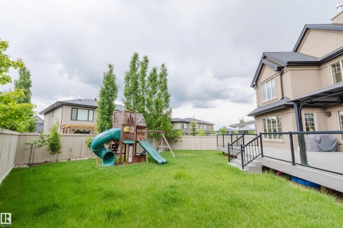 Expansive backyard featuring a manicured lawn, a privacy fence, and mature trees - 3435 Keswick Boulevard, Edmonton, AB 
