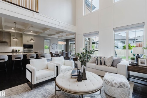 Soaring two-story living area featuring tall windows and rich wood-finish flooring - 3435 Keswick Boulevard, Edmonton, AB 