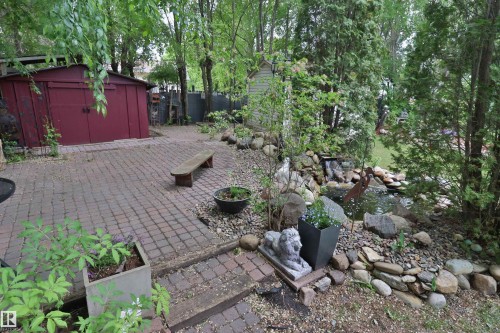 Brick paver patio and walkways with a built-in water feature and pond - 42 Alpaugh Crst, Leduc, AB 