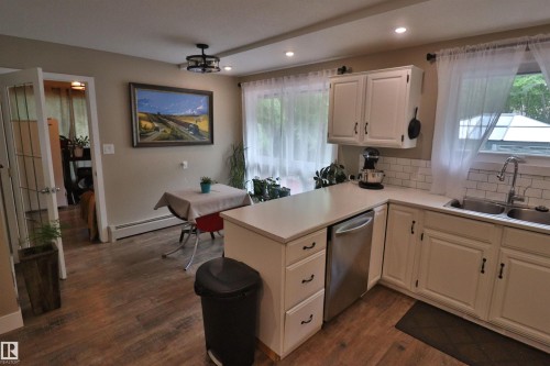 Well-appointed kitchen featuring white cabinetry, light countertops, subway tile backsplash, and stainless steel appliances - 42 Alpaugh Crst, Leduc, AB 