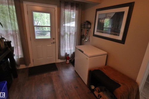 Rear entry door with integrated window, framed by full-length sheer curtains - 42 Alpaugh Crst, Leduc, AB 