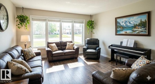 Bright living area featuring large picture windows, wood-finish flooring, and neutral wall tones - 42 Alpaugh Crst, Leduc, AB 