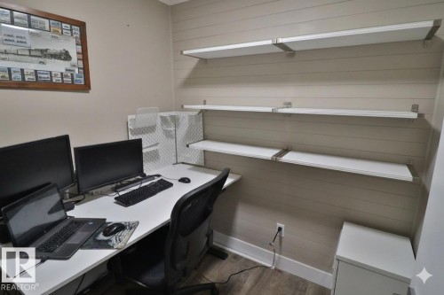 Dedicated workspace featuring shiplap accent wall, built-in shelving, durable flooring, and a white baseboard trim - 42 Alpaugh Crst, Leduc, AB 
