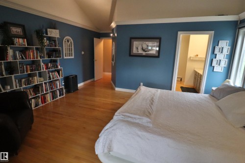 Spacious room featuring wood-finish flooring, vaulted ceiling, and built-in shelving - 42 Alpaugh Crst, Leduc, AB 