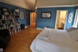 Spacious room featuring wood-finish flooring, vaulted ceiling, and built-in shelving - 