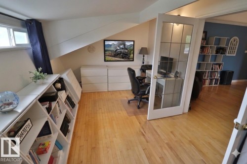 Wood-finish flooring throughout, featuring a built-in shelving unit with a unique geometric design - 42 Alpaugh Crst, Leduc, AB 