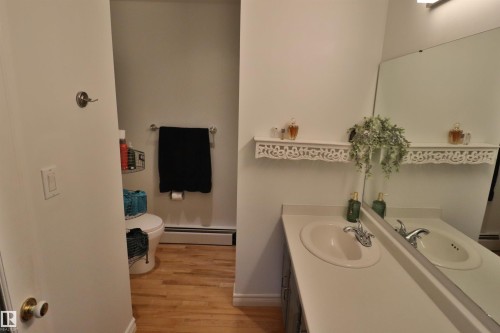 Bathroom featuring a vanity with an integrated sink, a large wall-mounted mirror, and decorative wall shelving - 42 Alpaugh Crst, Leduc, AB 