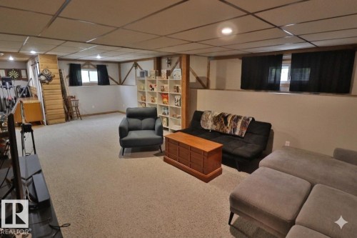 Spacious lower-level area with recessed lighting, carpet flooring, and exposed ceiling beams - 42 Alpaugh Crst, Leduc, AB 
