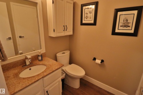 Bathroom featuring a white vanity with a granite-finish countertop, undermount sink, and chrome faucet - 42 Alpaugh Crst, Leduc, AB 