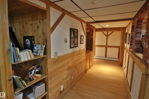Hallway featuring wood-finish flooring, half-timber wall accents, integrated shelving, and recessed lighting - 42 Alpaugh Crst, Leduc, AB 
