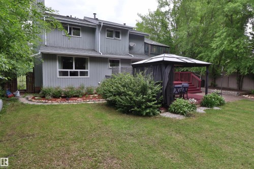 Expansive backyard featuring a large green space, a raised wood-finish deck, and a built-in privacy fence - 42 Alpaugh Crst, Leduc, AB 