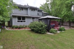 Expansive backyard featuring a large green space, a raised wood-finish deck, and a built-in privacy fence - 
