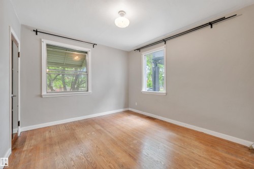 Interior room featuring wood-finish flooring, light gray wall paint, and white trim - 9624 77 Avenue, Edmonton, AB 