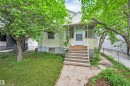 Front exterior featuring a covered porch with white railing, wood steps, and a screen door - 9624 77 Avenue, Edmonton, AB 