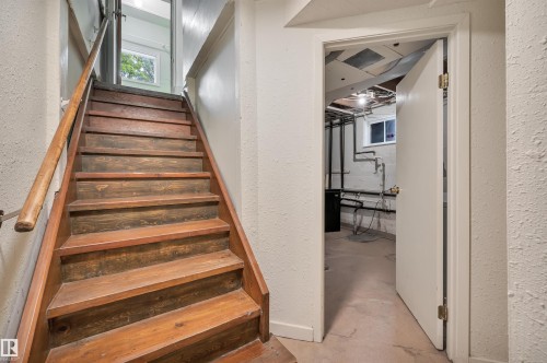 Wood-finish staircase with a natural wood handrail - 9624 77 Avenue, Edmonton, AB 