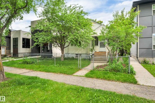Exterior featuring a light-colored siding facade, a front walkway, and mature trees - 9624 77 Avenue, Edmonton, AB 