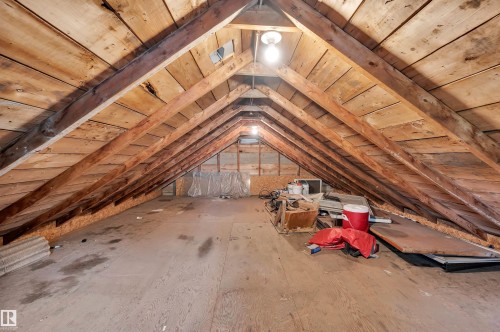 Vaulted attic space featuring exposed wood beams and planking, with a plywood floor - 9624 77 Avenue, Edmonton, AB 