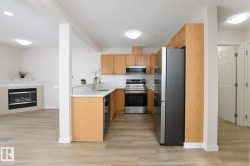 Kitchen featuring light wood cabinetry, stainless steel appliances, white subway tile backsplash, and light-toned countertops - 
