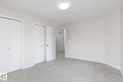 Interior room featuring light-colored carpeting and off-white walls - 