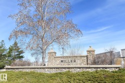 Stone veneer sign with "MILLER" lettering, featuring two stone pillars with capstones - 
