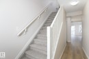 Carpeted staircase with white balusters and handrails - 55 14603 Miller Boulevard, Edmonton, AB 