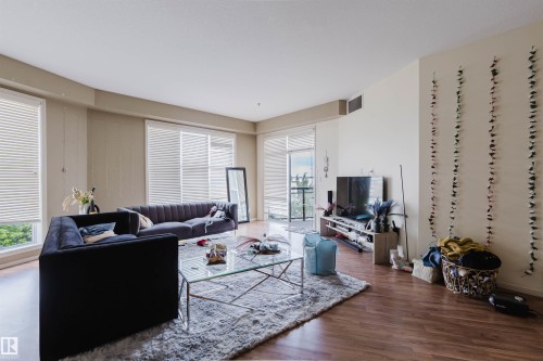 Open-concept living area featuring wood-finish flooring and light-toned walls - 323 4831 104A Street, Edmonton, AB 