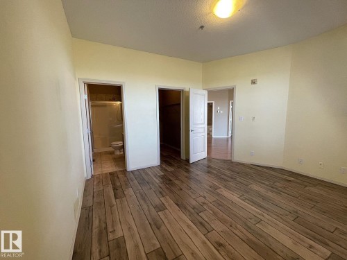 Wood-finish flooring throughout, featuring a neutral color palette and recessed lighting - 323 4831 104A Street, Edmonton, AB 