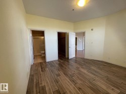 Wood-finish flooring throughout, featuring a neutral color palette and recessed lighting - 
