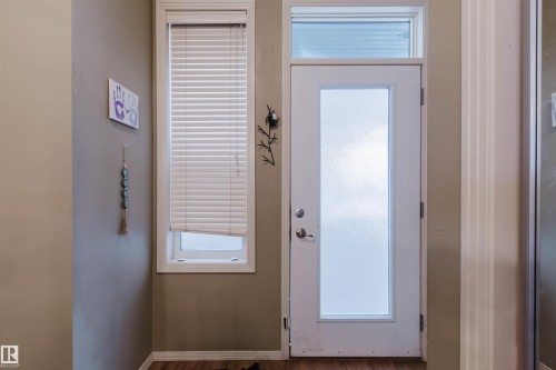 Entryway featuring a white door with a frosted glass panel and an overhead transom window - 323 4831 104A Street, Edmonton, AB 