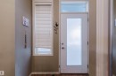 Entryway featuring a white door with a frosted glass panel and an overhead transom window - 323 4831 104A Street, Edmonton, AB 