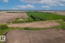 Expansive agricultural land featuring a central residential structure, diverse crop fields, and established perimeter tree lines - 0 0, Rural Sturgeon County, AB 