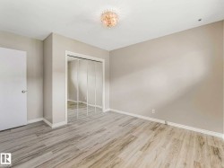 Room featuring wood-finish flooring, neutral wall tones, and white baseboards - 