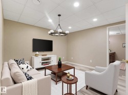 Finished living area featuring wood-finish flooring, recessed lighting, and a contemporary chandelier - 