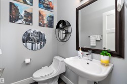 Modern pedestal sink with a chrome faucet, complemented by a framed mirror - 