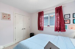 Bedroom featuring a window with natural light, wall-to-wall carpeting, and white bi-fold closet doors - 