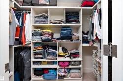 Custom walk-in closet featuring extensive built-in shelving, multiple hanging rods, corner storage, and integrated organizers - 