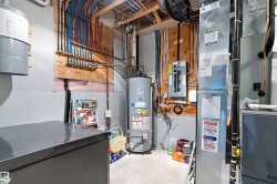 Utility area featuring a water heater, electrical panel, and exposed plumbing - 