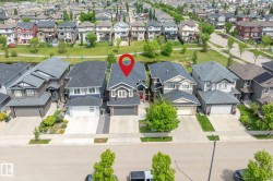 Contemporary two-story residence featuring a dark gray exterior, white trim accents, and an attached two-car garage - 