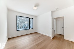 Light wood-finish flooring complements crisp white walls - 