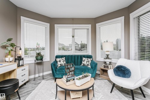 Bay window alcove featuring white blinds and light gray wood-finish flooring - 5610 57 Avenue, Beaumont, AB 