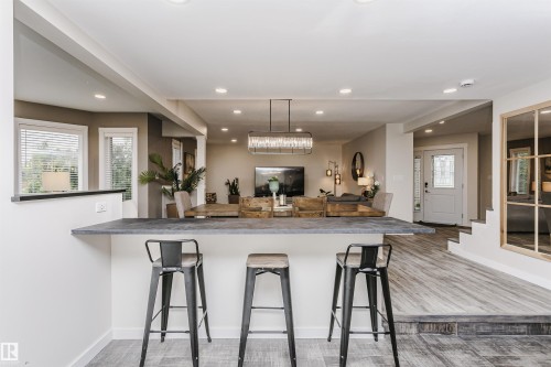 Breakfast bar with dark countertop, recessed lighting, and wood-finish flooring - 5610 57 Avenue, Beaumont, AB 