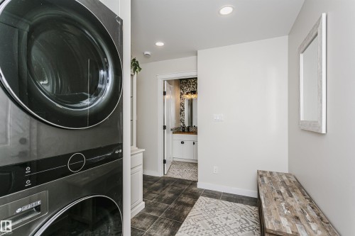 Hallway featuring dark tile flooring, a built-in white cabinet, and recessed lighting - 5610 57 Avenue, Beaumont, AB 
