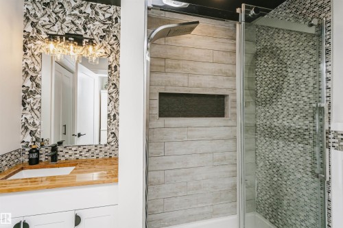 Shower with glass enclosure, wood-look tile surround, and built-in niche - 5610 57 Avenue, Beaumont, AB 