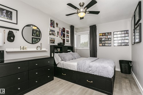 Bedroom featuring light gray walls, wood-finish flooring, and a ceiling fan with integrated lighting - 5610 57 Avenue, Beaumont, AB 