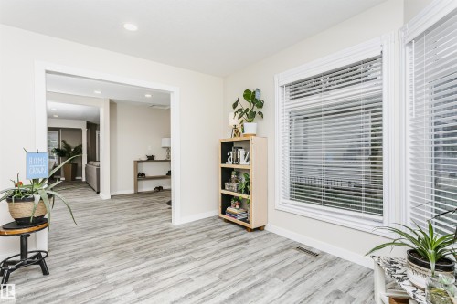 Room featuring wood-finish flooring, recessed lighting, and multiple windows with white blinds - 5610 57 Avenue, Beaumont, AB 