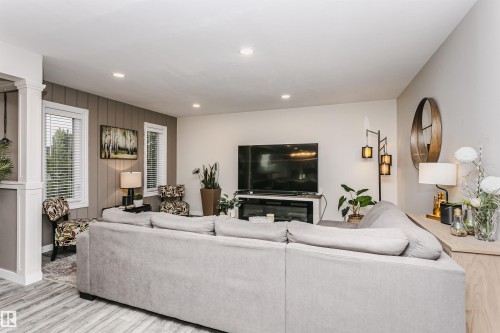 Spacious living area featuring wood-finish flooring, recessed lighting, and a neutral color palette - 5610 57 Avenue, Beaumont, AB 