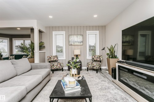 Spacious living area featuring wood-finish flooring, recessed lighting, and a modern built-in electric fireplace - 5610 57 Avenue, Beaumont, AB 